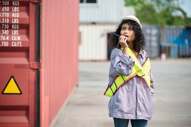 Femme en tenue de chantier qui parle dans un talki walki 