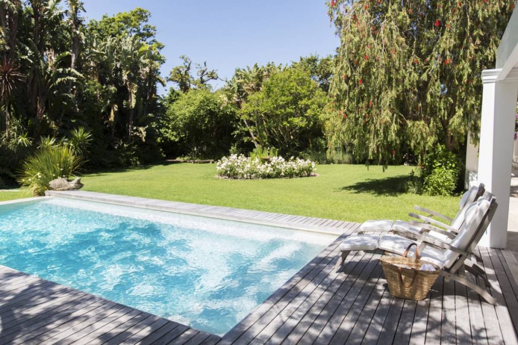 piscine sur mesure contruite dans un jardin sous le soleil